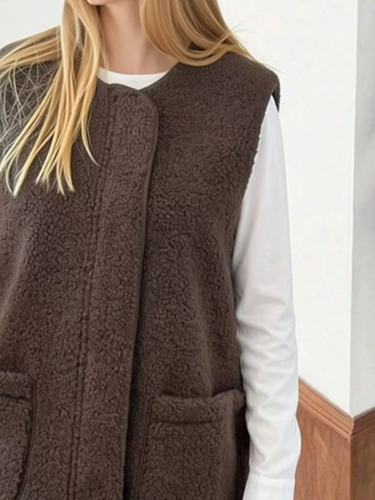 Close front view of the Coffee Brown sherpa vest worn over a white shirt.