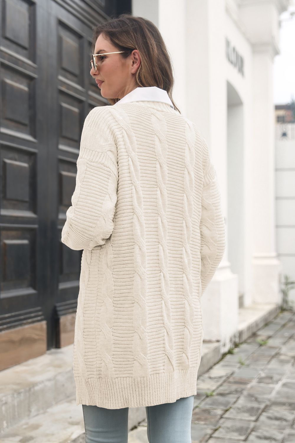 Back view of the Ivory cardigan showing its cable-knit panels and length.