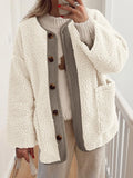 Cream textured jacket with contrast trim and a button front, worn over a cream sweater.