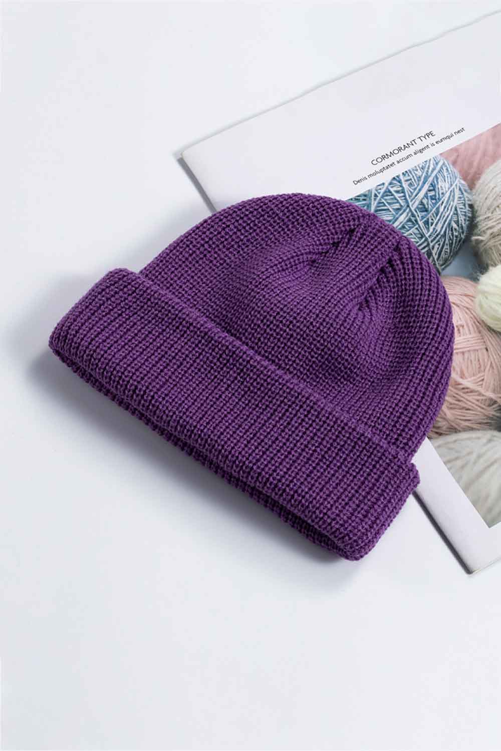 Purple knit cuff beanie displayed at an angle on a printed page.