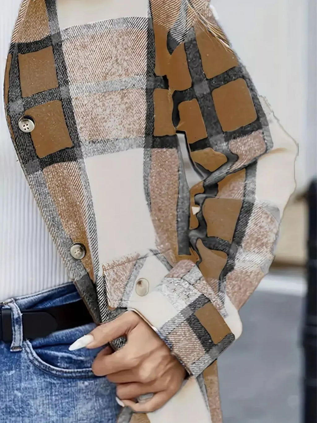 Close-up of the tan plaid shacket's front buttons, pocket flap and sleeve.
