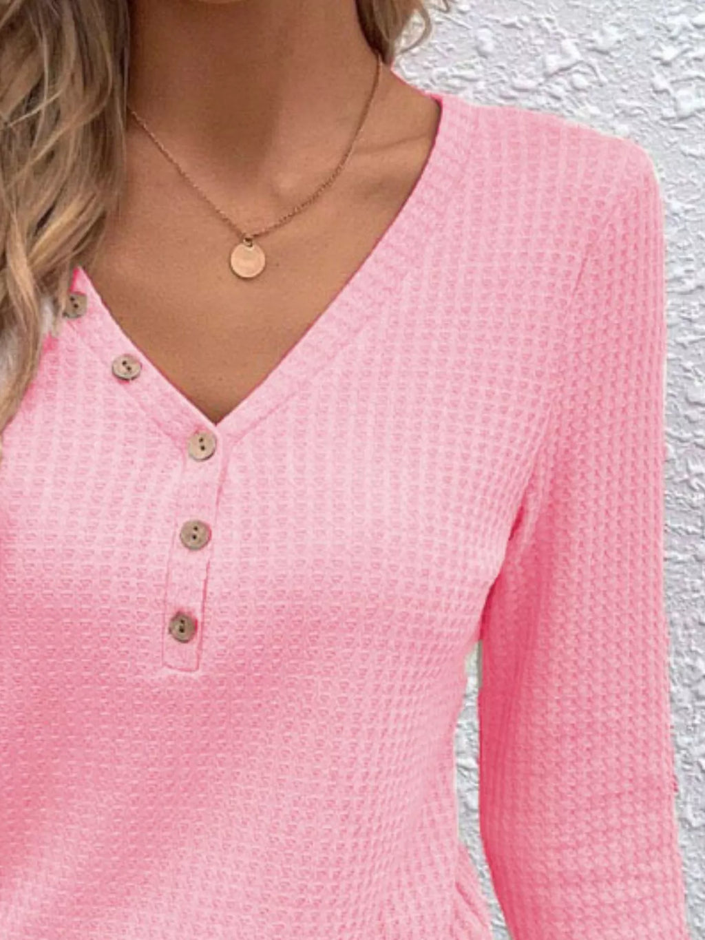 Close view of the Blush Pink top showing its waffle texture, V-neck and buttons.