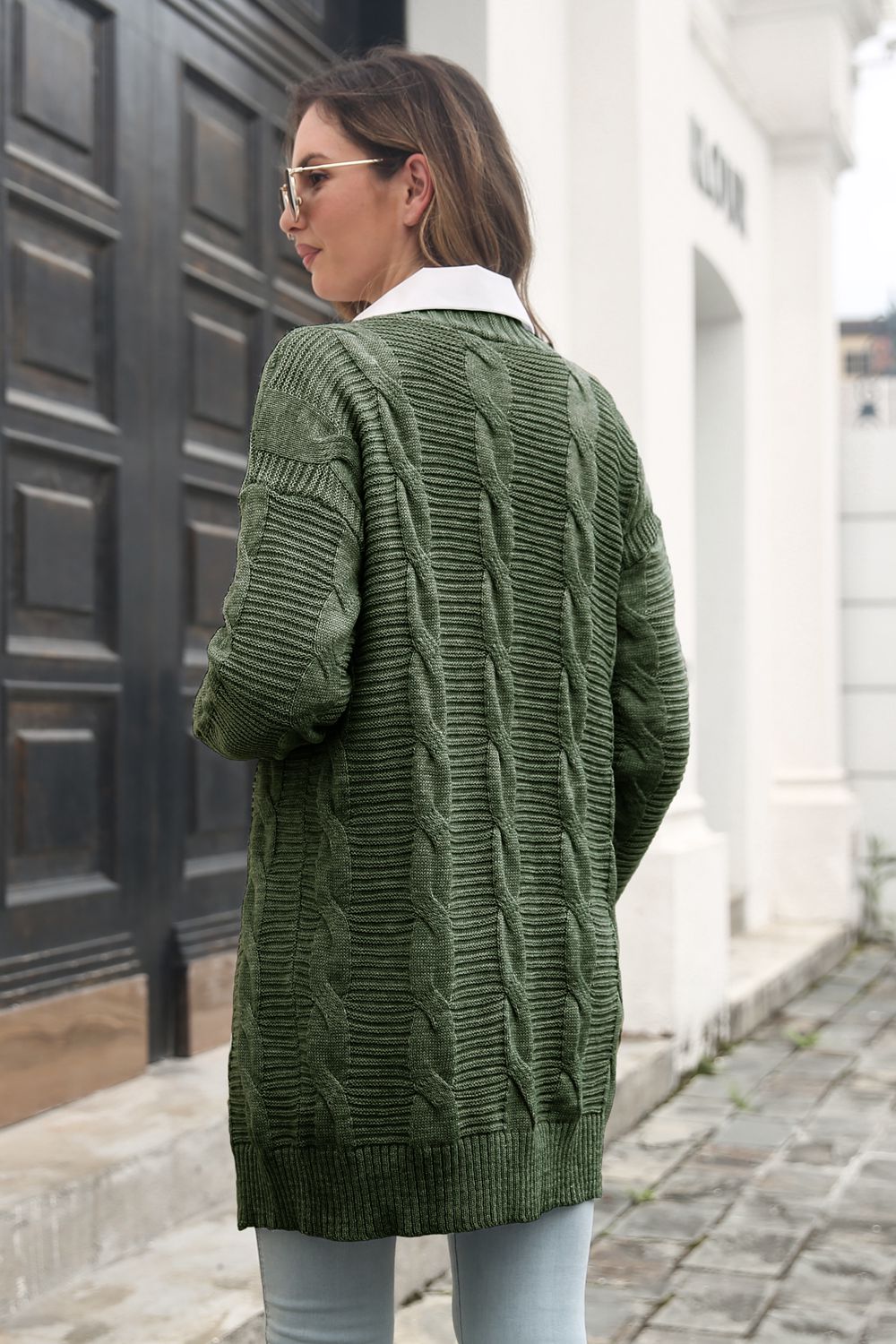 Back view of the Army Green cardigan showing its cable-knit panels.