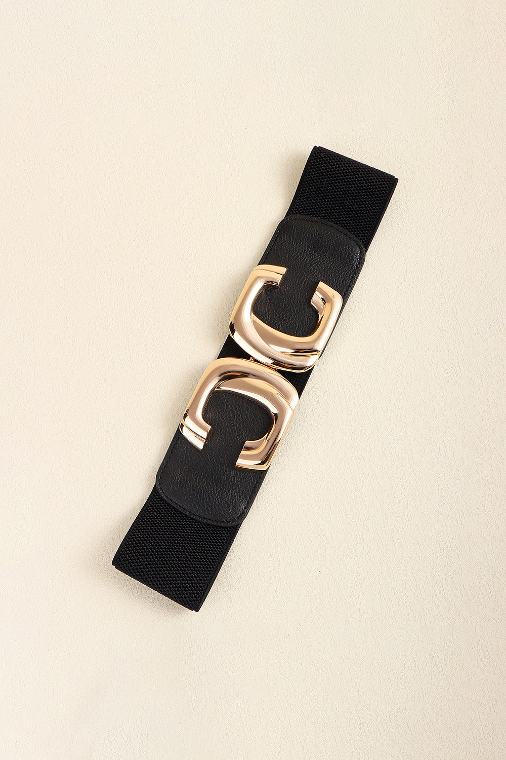 Black waist belt laid diagonally with the metal buckle fastened.