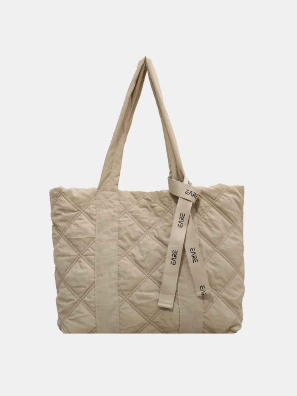 Cream quilted tote with long handles and a ribbon against a plain background.