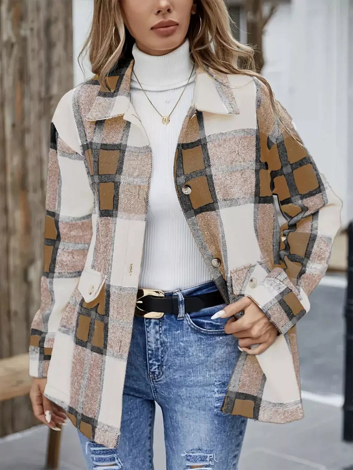 Tan and cream plaid shacket worn open over a white turtleneck and jeans.