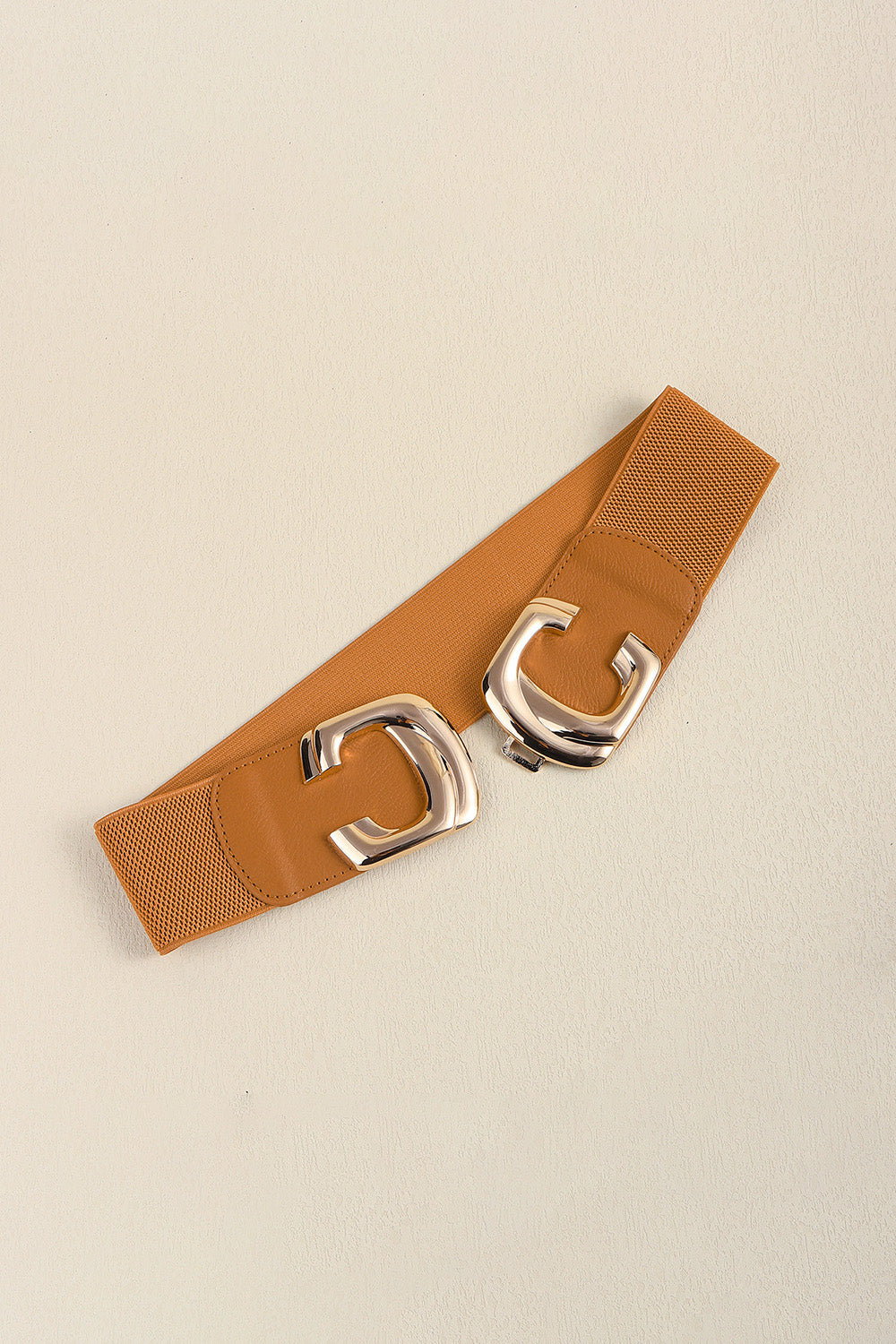 Caramel waist belt laid diagonally with the two buckle pieces separated.