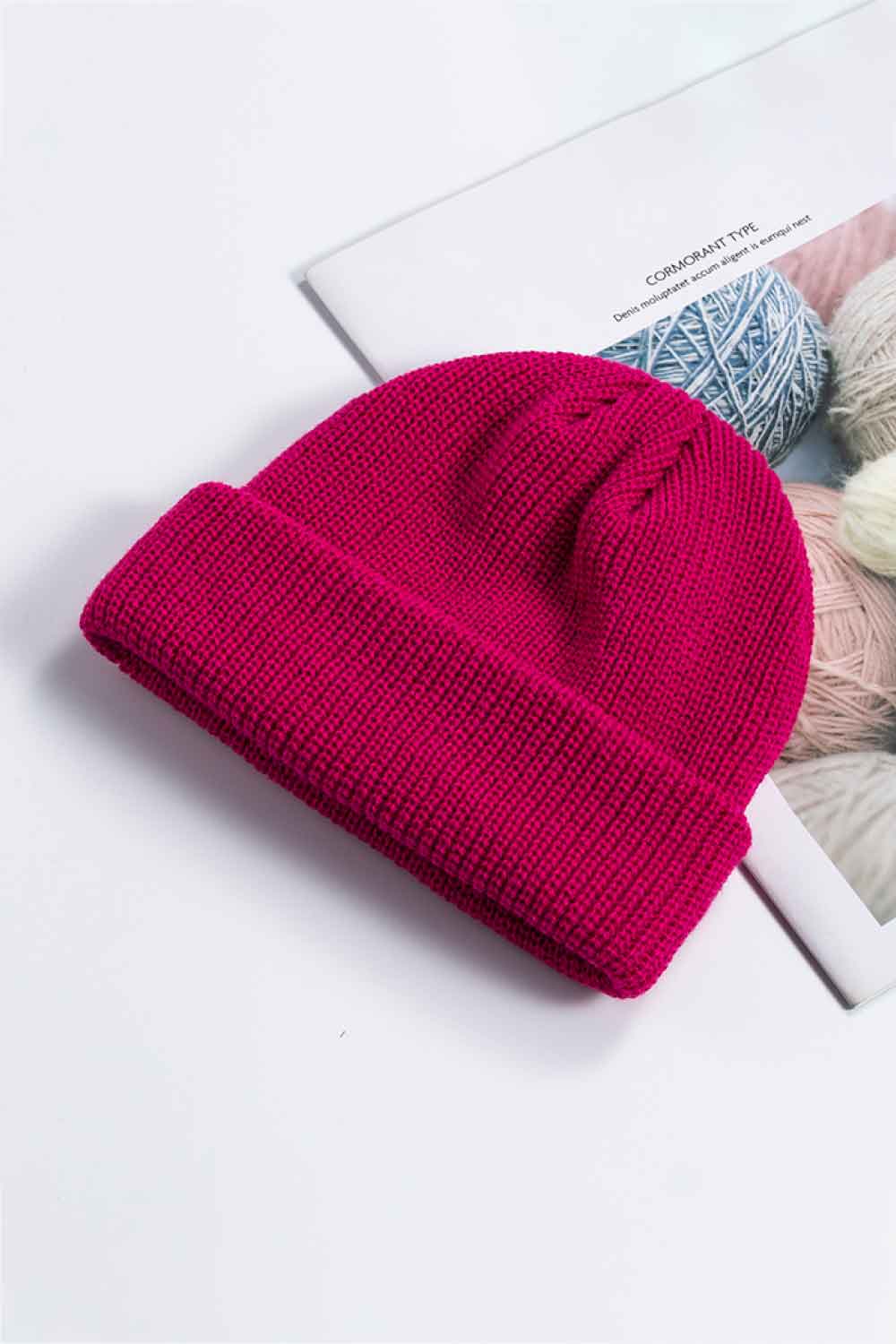 Fuchsia knit beanie shown with its cuff folded up.