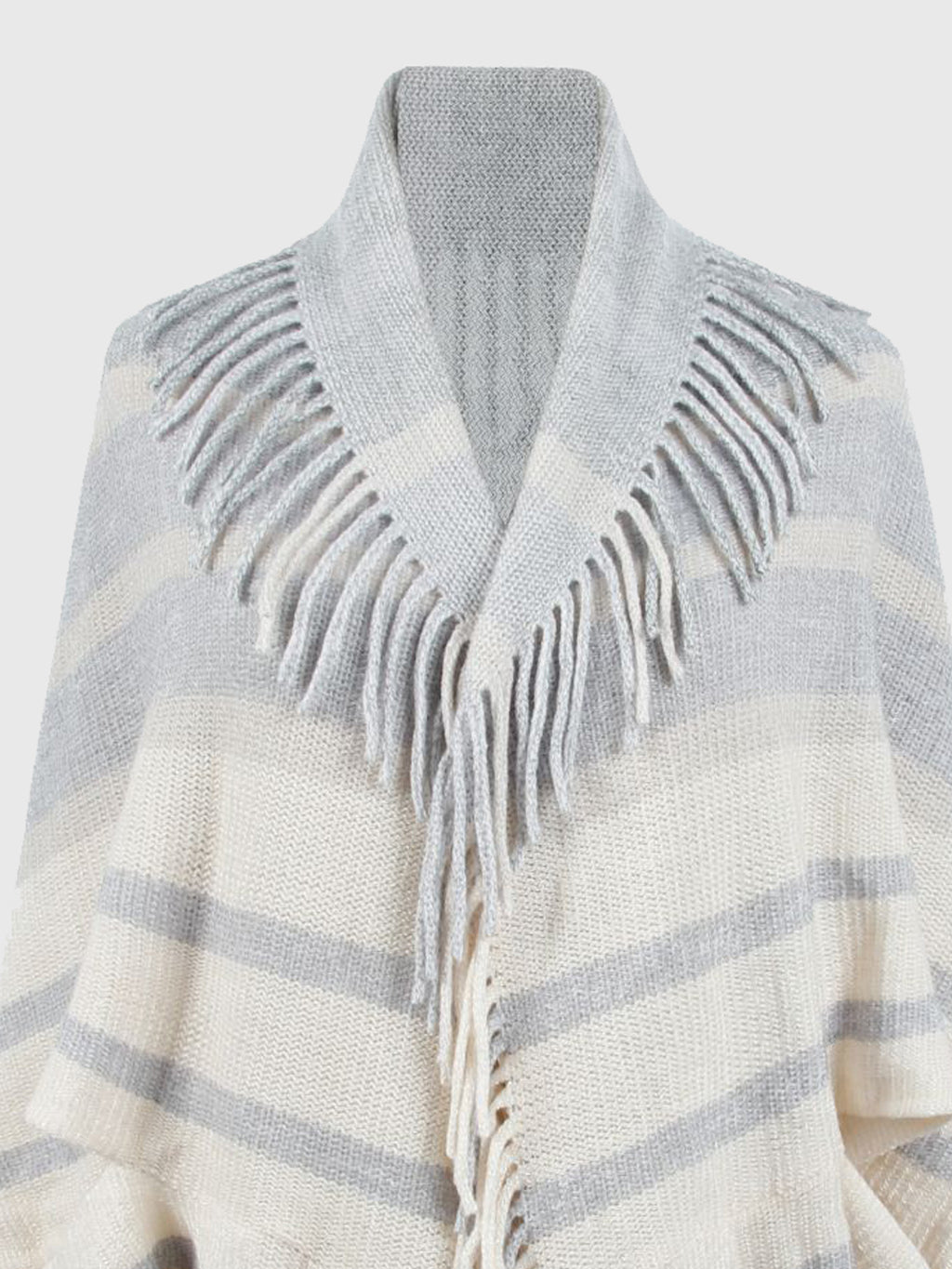 Close-up of the light gray and cream poncho's striped front and neckline fringe.