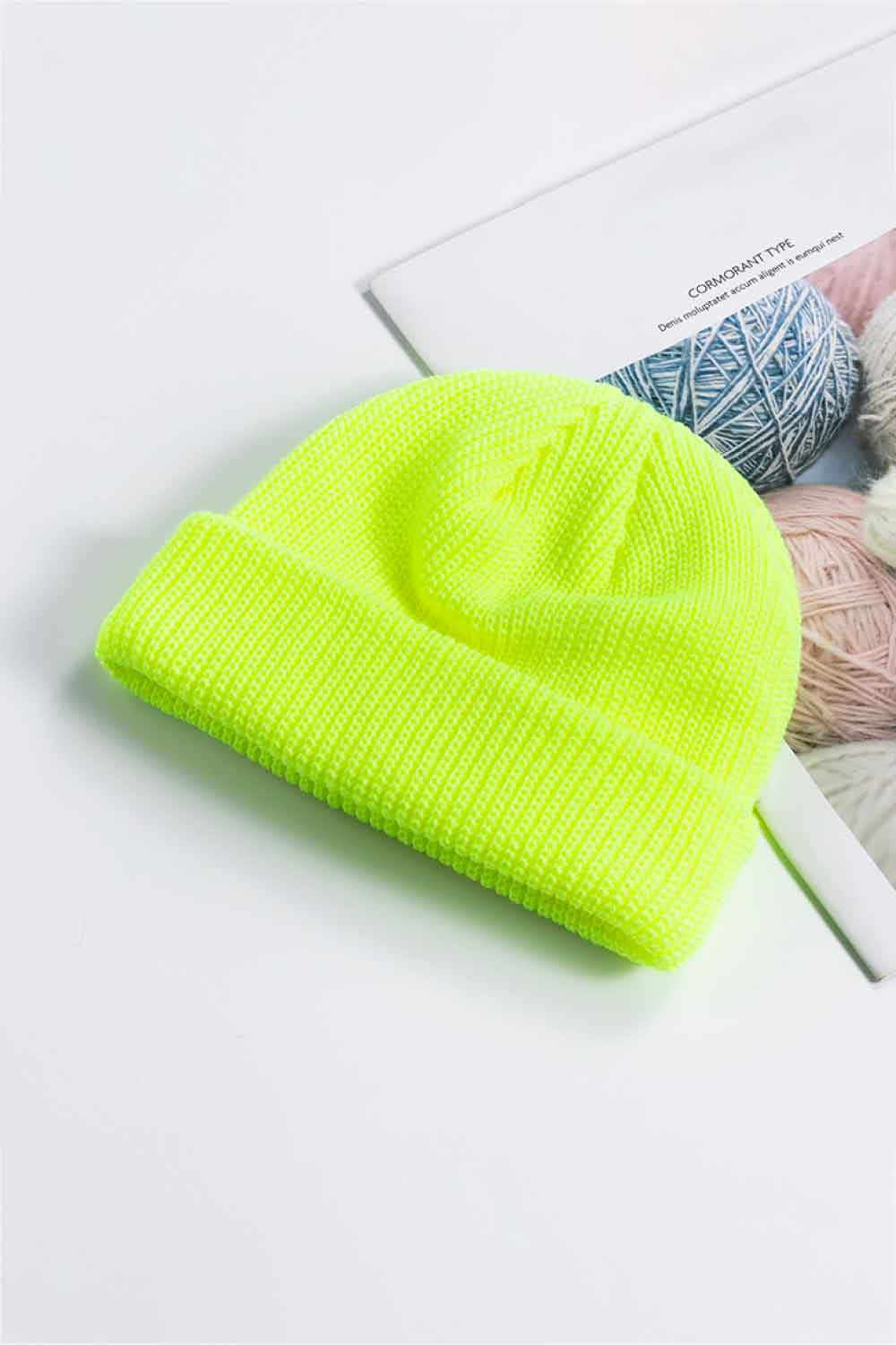 Neon yellow knit beanie shown with its cuff folded up.