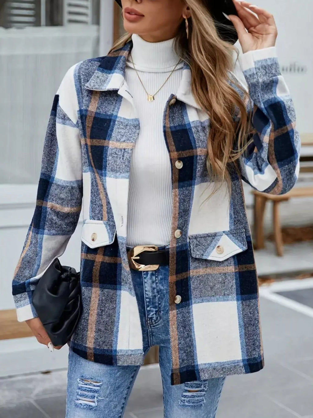 Blue plaid shacket shown from the front with a black clutch held at the side.
