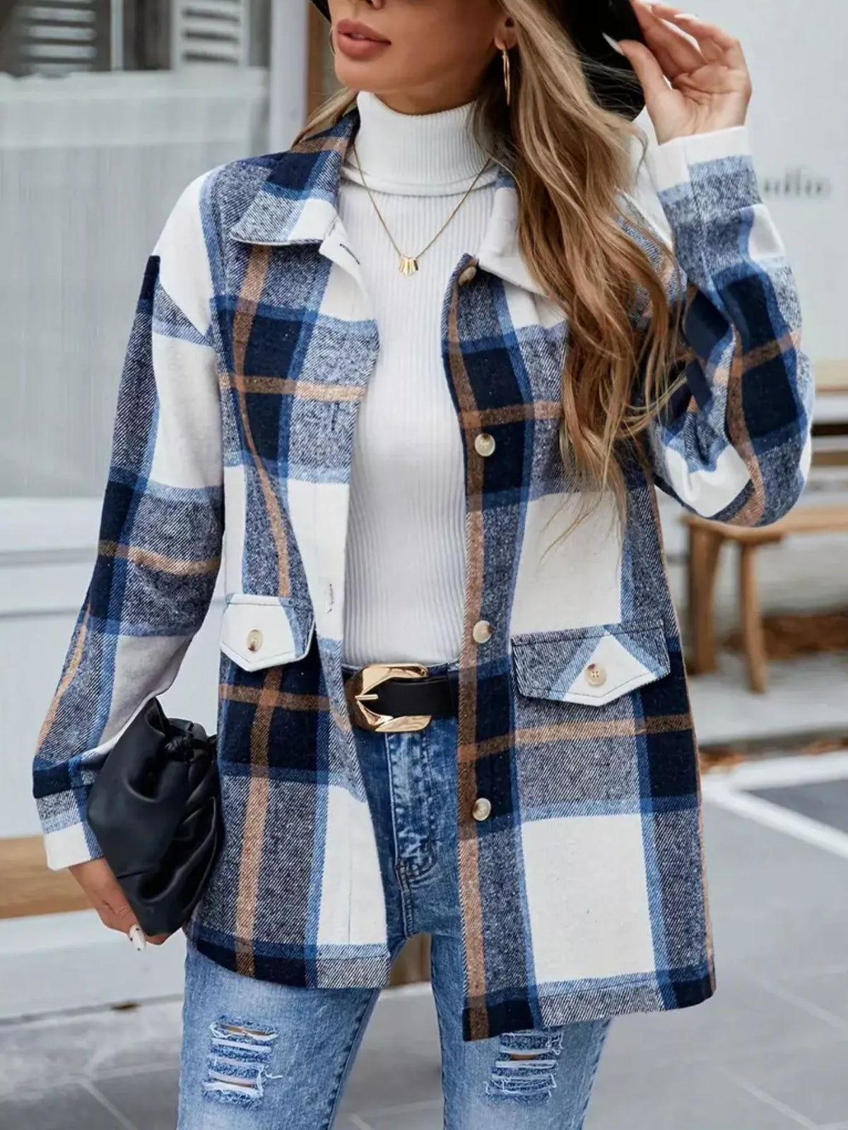 Blue plaid shacket shown from the front with a black clutch held at the side.
