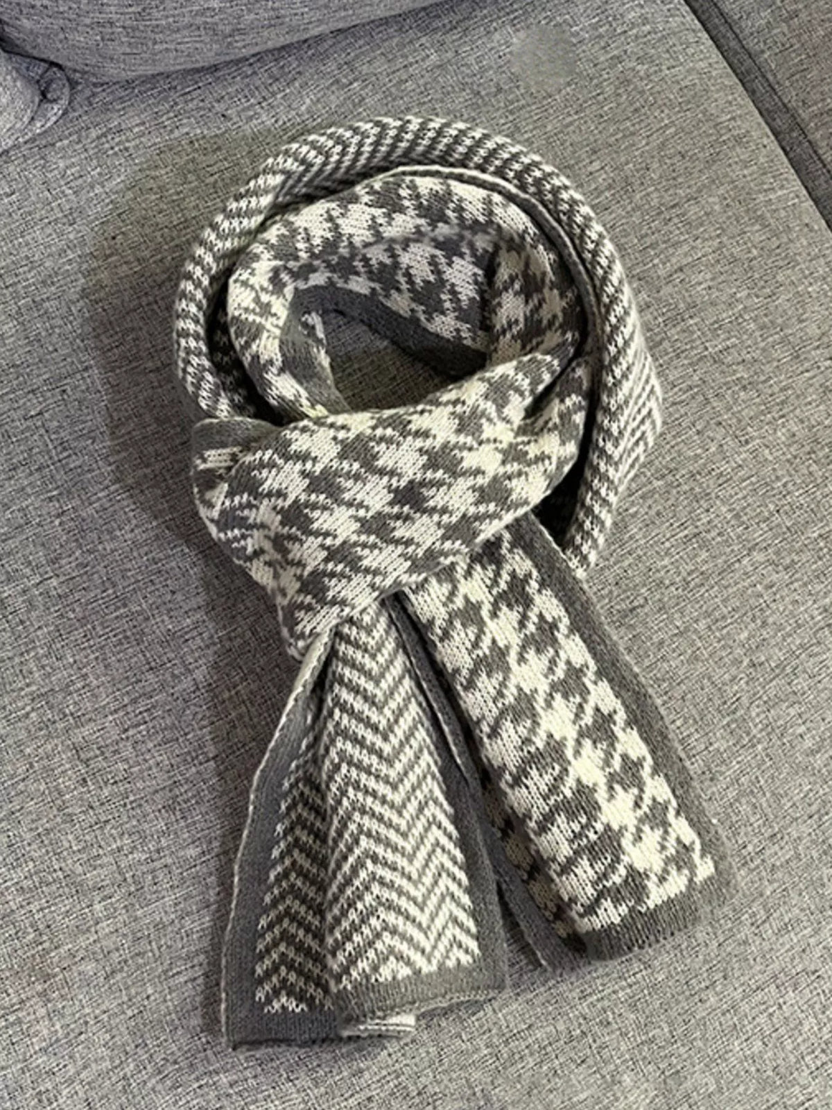 Grey scarf folded to show houndstooth and chevron patterns.