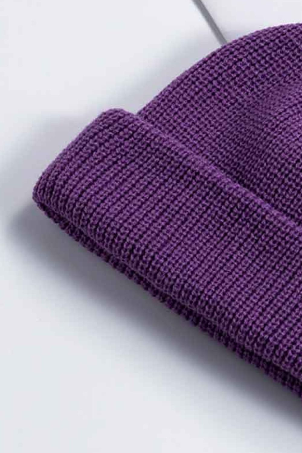 Close-up of the purple beanie's folded knit cuff.