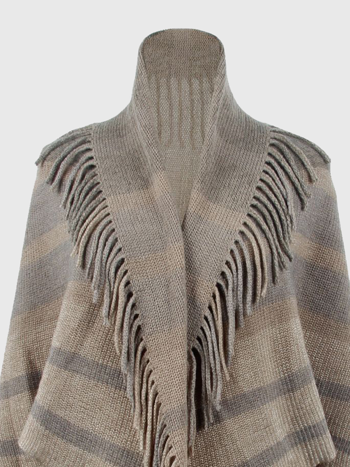 Close-up of the taupe poncho's open neckline, stripes and fringe.