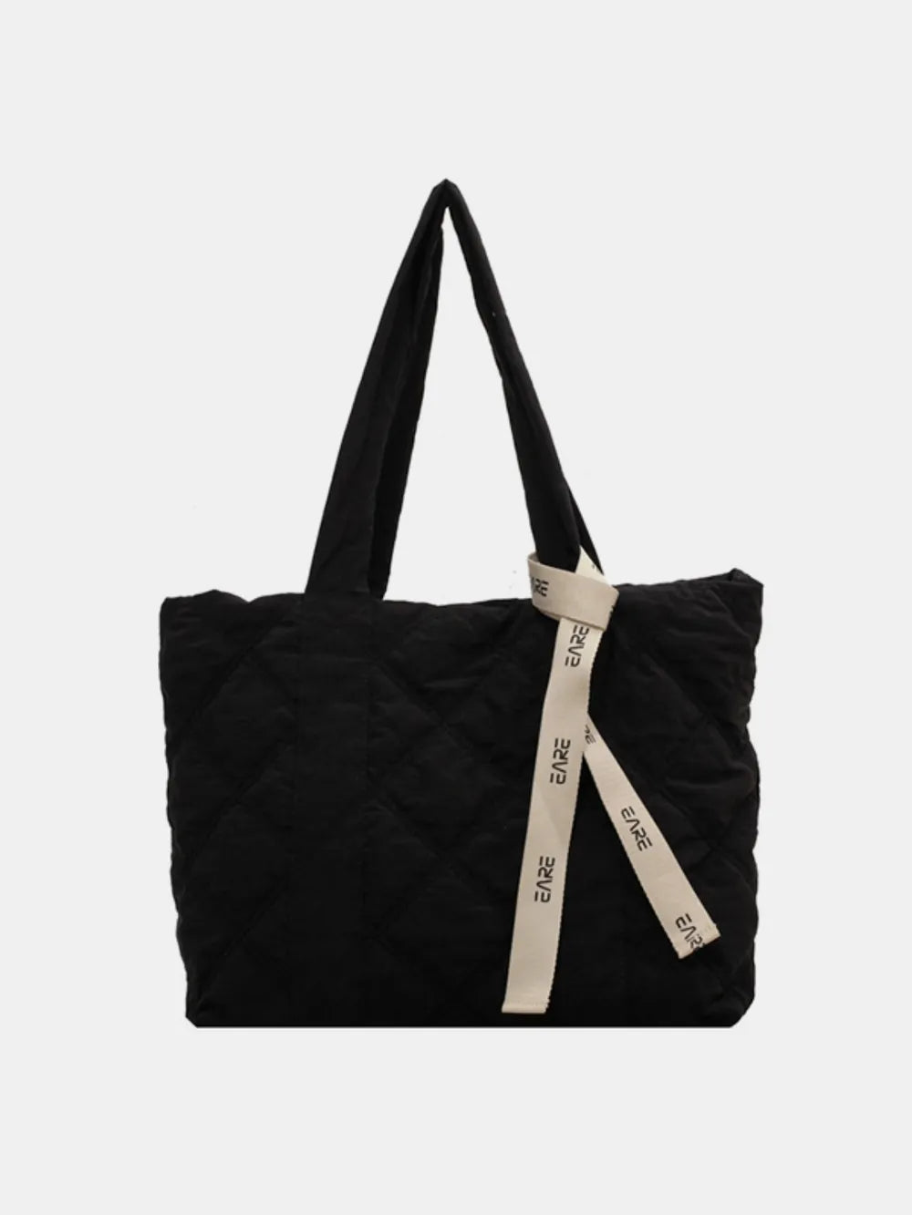 Black quilted tote with long handles and a cream ribbon against a plain background.