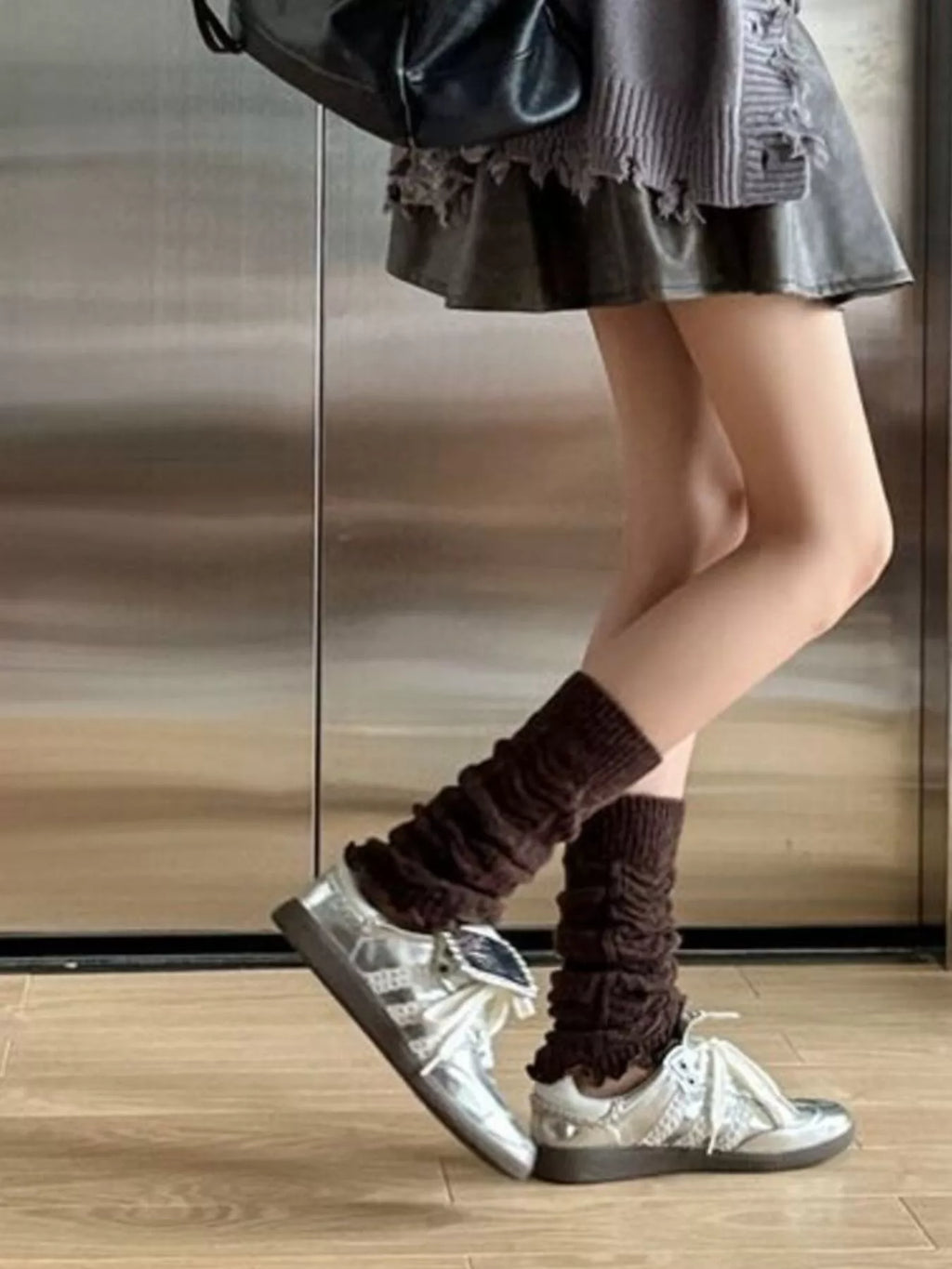 Side view of coffee brown leg warmers worn with silver sneakers.