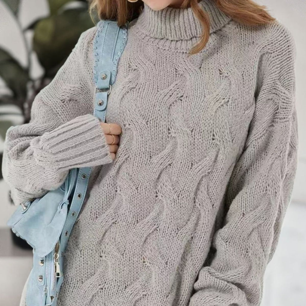 Close-up of the light gray dress's turtleneck, cable-knit front and ribbed sleeve cuff.