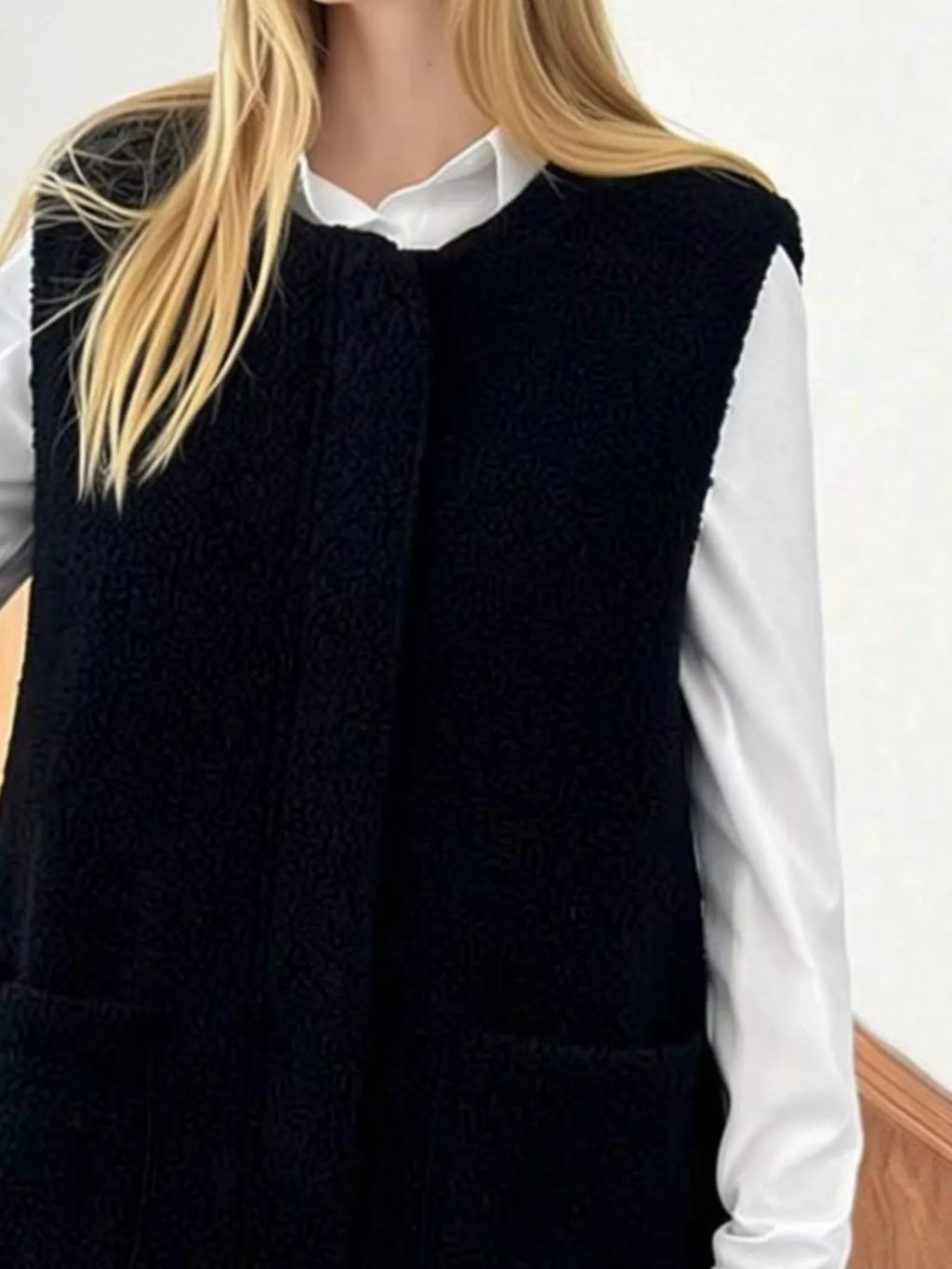 Close front view of the Black sherpa vest worn over a white shirt.