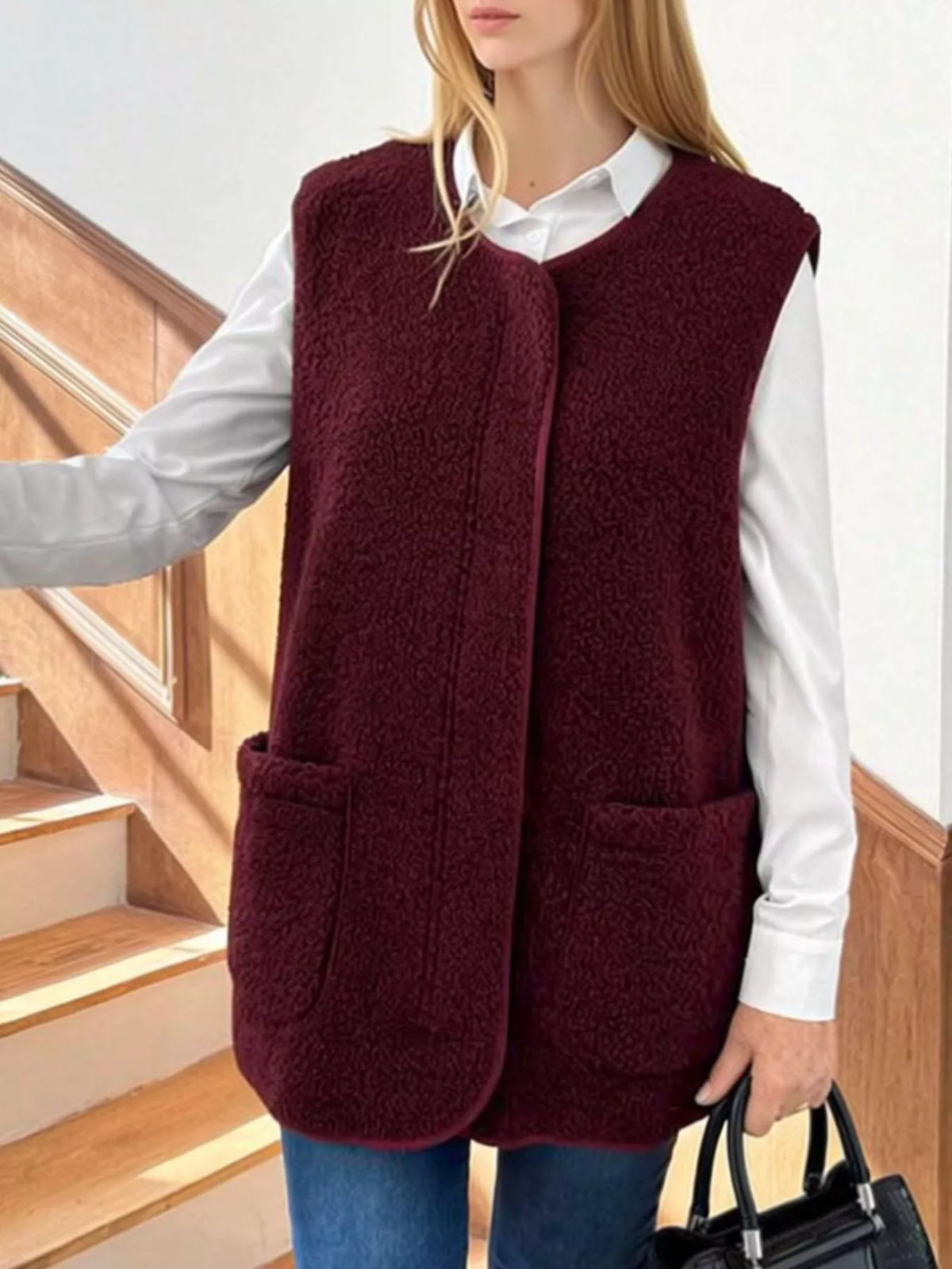 Burgundy sherpa vest with two patch pockets, worn over a white shirt.