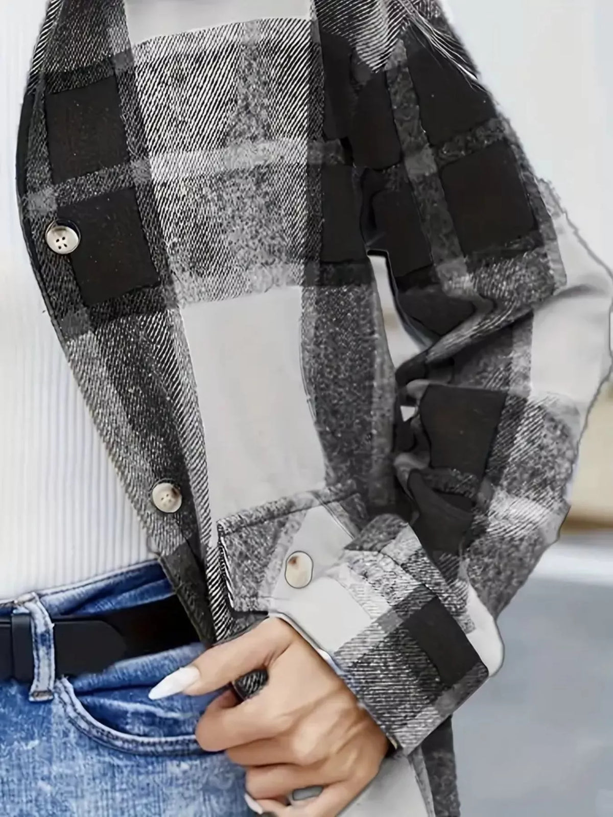 Close-up of the gray plaid shacket's front buttons, pocket flap and cuff.