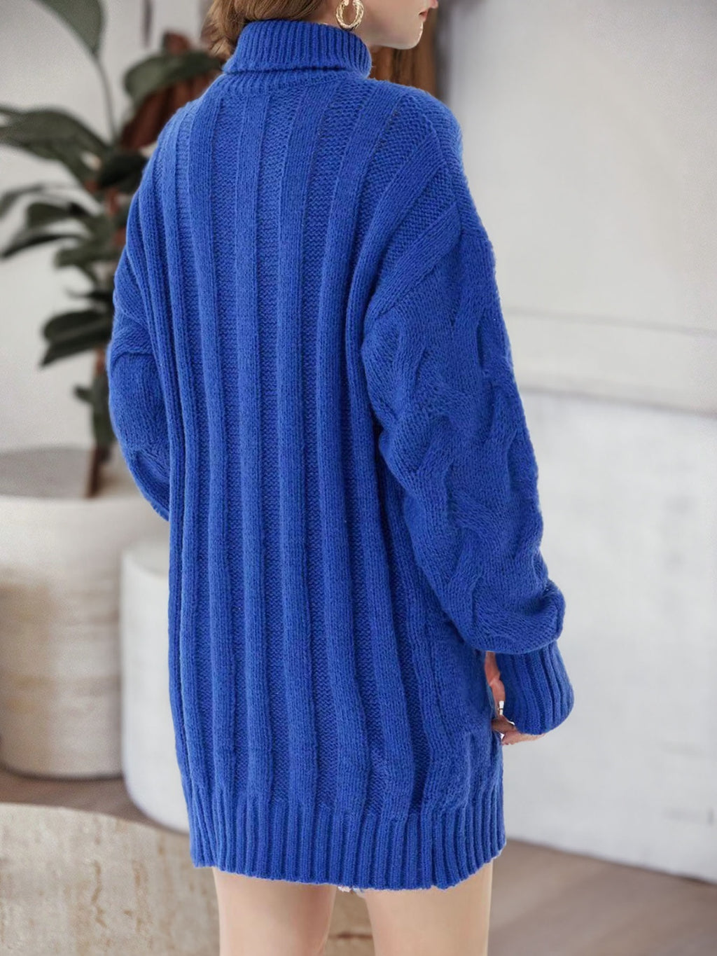 Back view of the blue sweater dress showing vertical knit ribs and long sleeves.